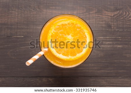 Fresh orange juice in glass on wooden background.