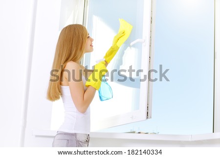 girl washing windows at home