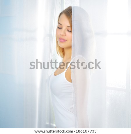 Teenager girl at the window. light background