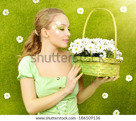 Smiling girl with a basket of flowers on a green background