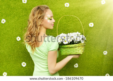 Smiling girl with a basket of flowers on a green background