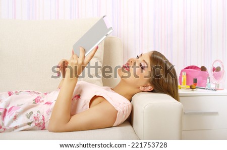 Young attractive girl with tablet pc on light background