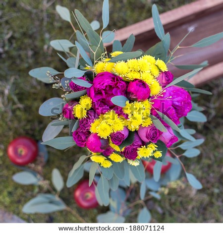 Bouquet of summer flowers with red apples in the box