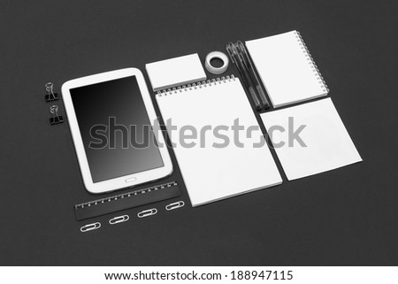 Set of variety blank office objects organized for company presentation or branding identity with blank modern devices. Isolated on gray paper background.
