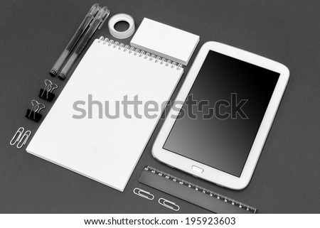 Set of variety blank office objects organized for company presentation or branding identity with blank modern devices. Isolated on gray paper background.