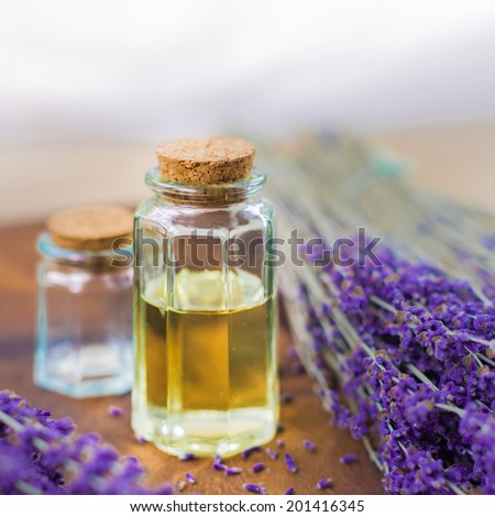 Lavender oil for spa on a wooden desk with lavender flowers