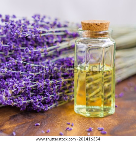 Lavender oil for spa on a wooden desk with lavender flowers
