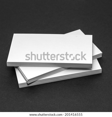 Business card template for branding identity with blank modern devices and modern abstract logo print. Isolated on black paper background.