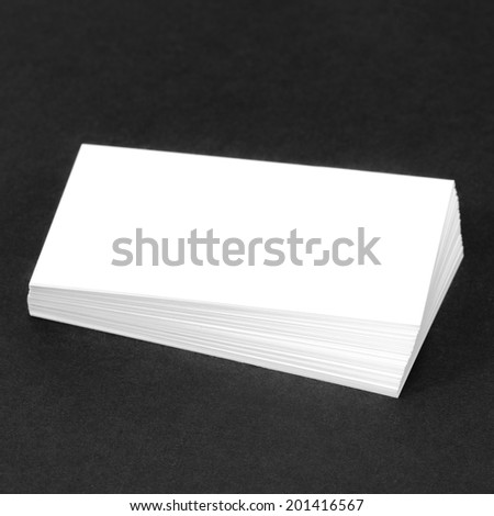 Business card template for branding identity with blank modern devices and modern abstract logo print. Isolated on black paper background.