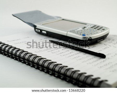 PDA Modern Mobile Cellphone with Stylus on Traditional Paper Lined White Notebook Paper Showing a Home Budget Financial Plan