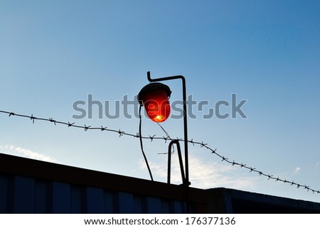 The broken red light on the construction fence