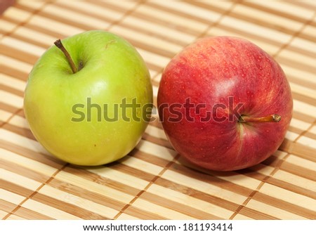Red and green apple on background wooden wicker striped napkin