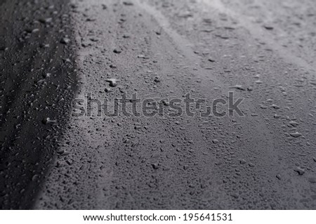 Texture black car hood with rain drops