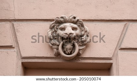 Fragment an ancient building with window decorated with bas-relief lion\'s head