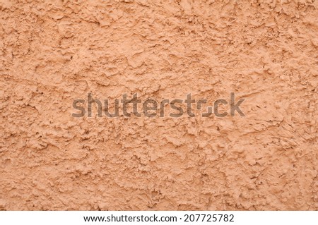Texture of wall covered with pink stucco relief