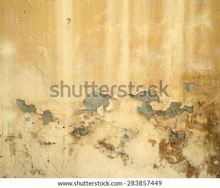 Texture of old rustic wall covered with yellow stucco