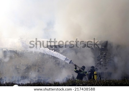 VARNA, ITALY - SEPTEMBER 10, 2014: Firefighters with masks extinguish the fire on the highway after a truck collision in Varna on 10 September 2014