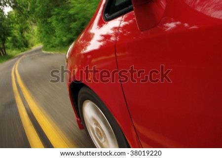 Red car driving through a green road
