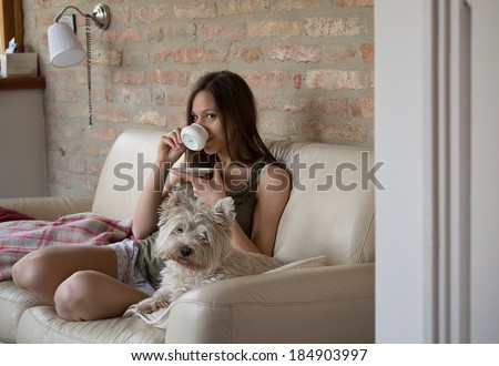Girl drinks coffee and relax with dog