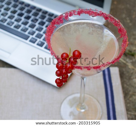 Working at home with laptop and currants cocktail
