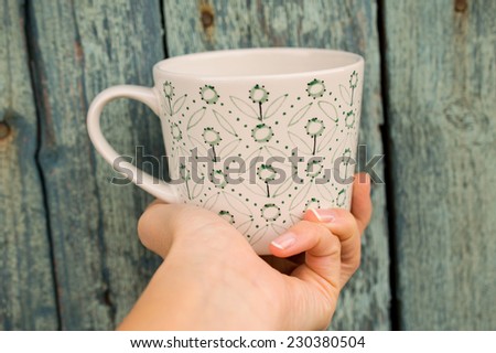 Norway feeling - green wood background and mug in hand