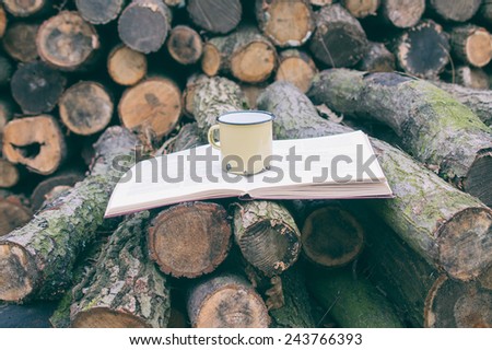 Log, book and mug - reading in the nature