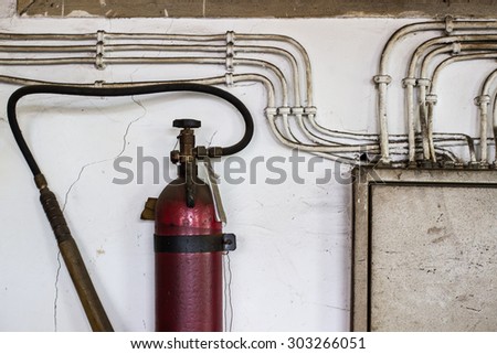 Old electrical cabinet and fire extinguisher hanging on the wall. old construction office.