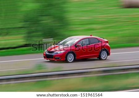 Very fast driving red Japanese modern hatchback