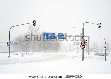 Empty winter road with traffic signs in snow storm