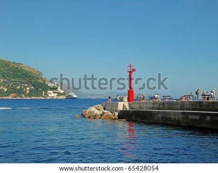 Long stone mole with red lighthouse in Dubrovnik in Croatia