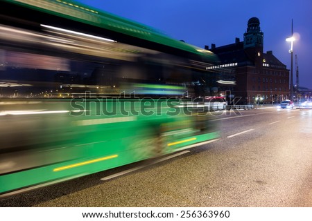 Fast driving green bus creating motion blur effect