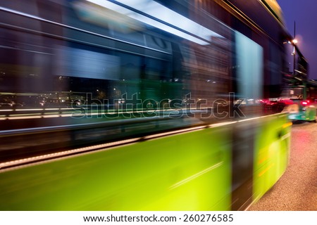 Fast driving green bus in the night city