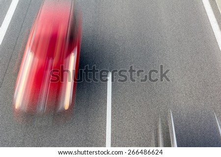 Red speeding car blurred on a highway