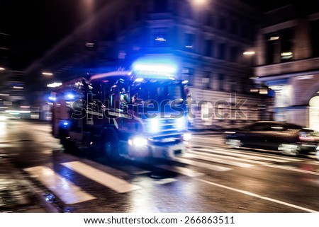 Fast driving fire truck in a night city