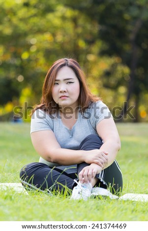 Obese woman relaxing on the grass.