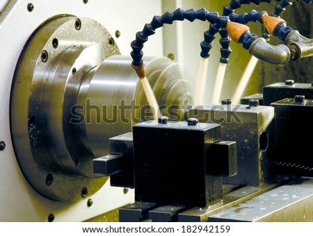 metal blank machining process on lathe with cutting tool and coolant at steel manufacturing