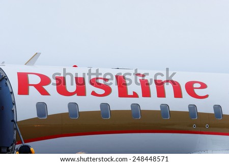 NIZHNY NOVGOROD. RUSSIA. January 26, 2015. STRIGINO AIRPORT. Bright red logo of RusLine airline aboard. Close up.