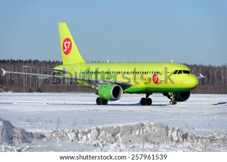 NIZHNY NOVGOROD. RUSSIA. FEBRUARY 17, 2015. The bright green Airbus A-320 plane with a red logo of the S7 company goes on a snow-covered airfield