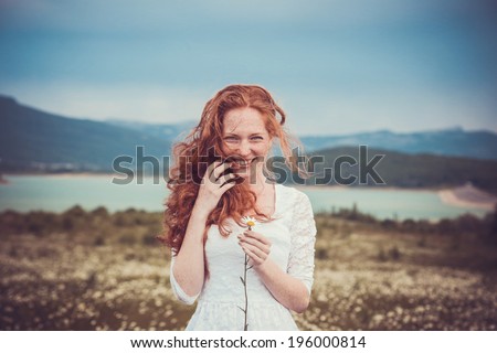 Beautiful woman enjoying field, pretty girl with freckles relaxing outdoor, having fun, holding plant, happy young lady and spring green nature, harmony concept