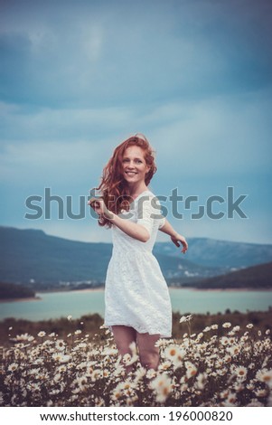 Beautiful woman enjoying field, pretty girl with freckles relaxing outdoor, having fun, holding plant, happy young lady and spring green nature, harmony concept