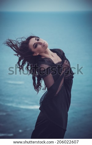 Closeup Portrait of beautiful young woman. Young active people. Outdoors.  Smoky eyes. Fashion colors. Cold sea