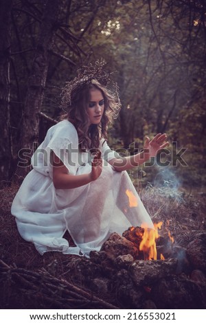 portrait of beautiful girl with magic eyes in wreath and dress in the forest outdoor. Bright witch, druid, shaman. book cover