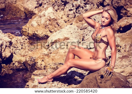 Beautiful sexy bodybuilder. Militant, independent girl Amazon. Like the hero of Boris Vallejo. In a fantasy costume in marine rocks