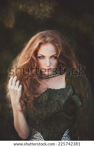 Beautiful woman with red hair in fashion military clothing