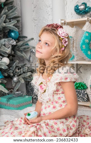 pretty little girl near the new year tree. beautiful girl in a wreath and dress near Christmas tree waiting for holiday