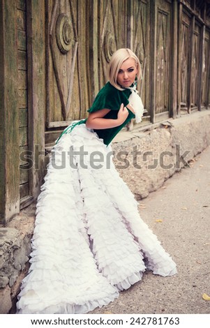 A woman like a princess in an vintage dress in fairy park. Mysterious woman dressed in scenic fashion clothes. Green labyrinth. Model plus