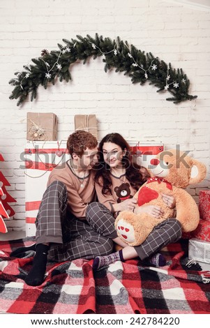 young happy smiling casual couple. warm light. morning after Christmas, in pajamas