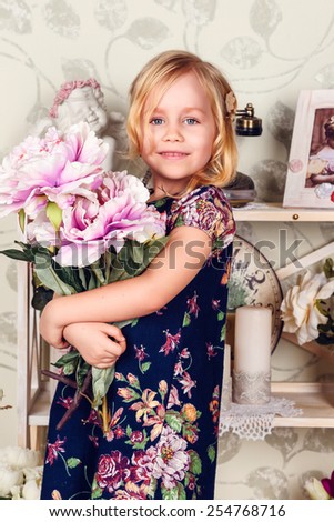 Cute little child girl with spring flowers, happy baby girl with basket of flowers. retro phone, a rack with flowers and cute attributes