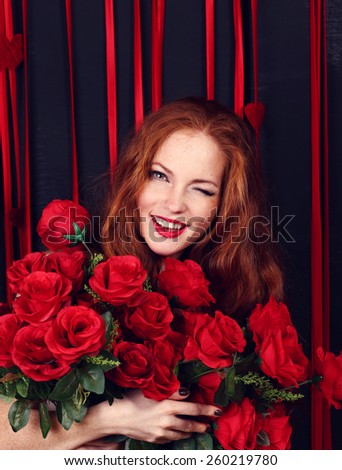 Beautiful Fashion Girl with Roses. Black background. Red hair girl. Happiness, Freshness, Beauty, Youth.
