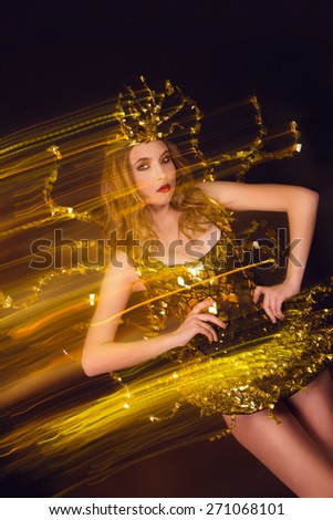 sexy disco party woman dressed in a unique golden costume with metal wings. Perfect for stylish club, disco and fashion events